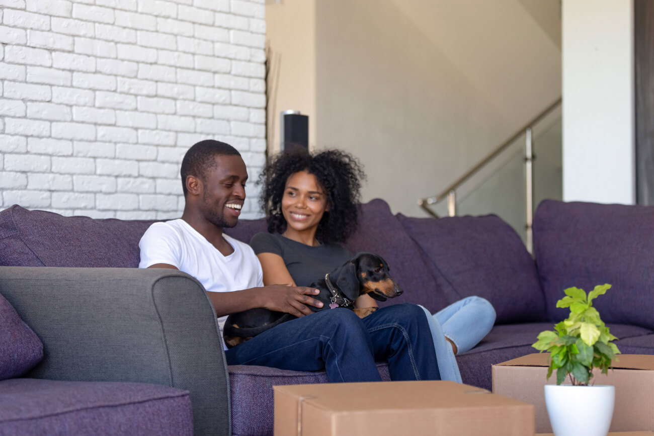 people sitting on the couch with their dog